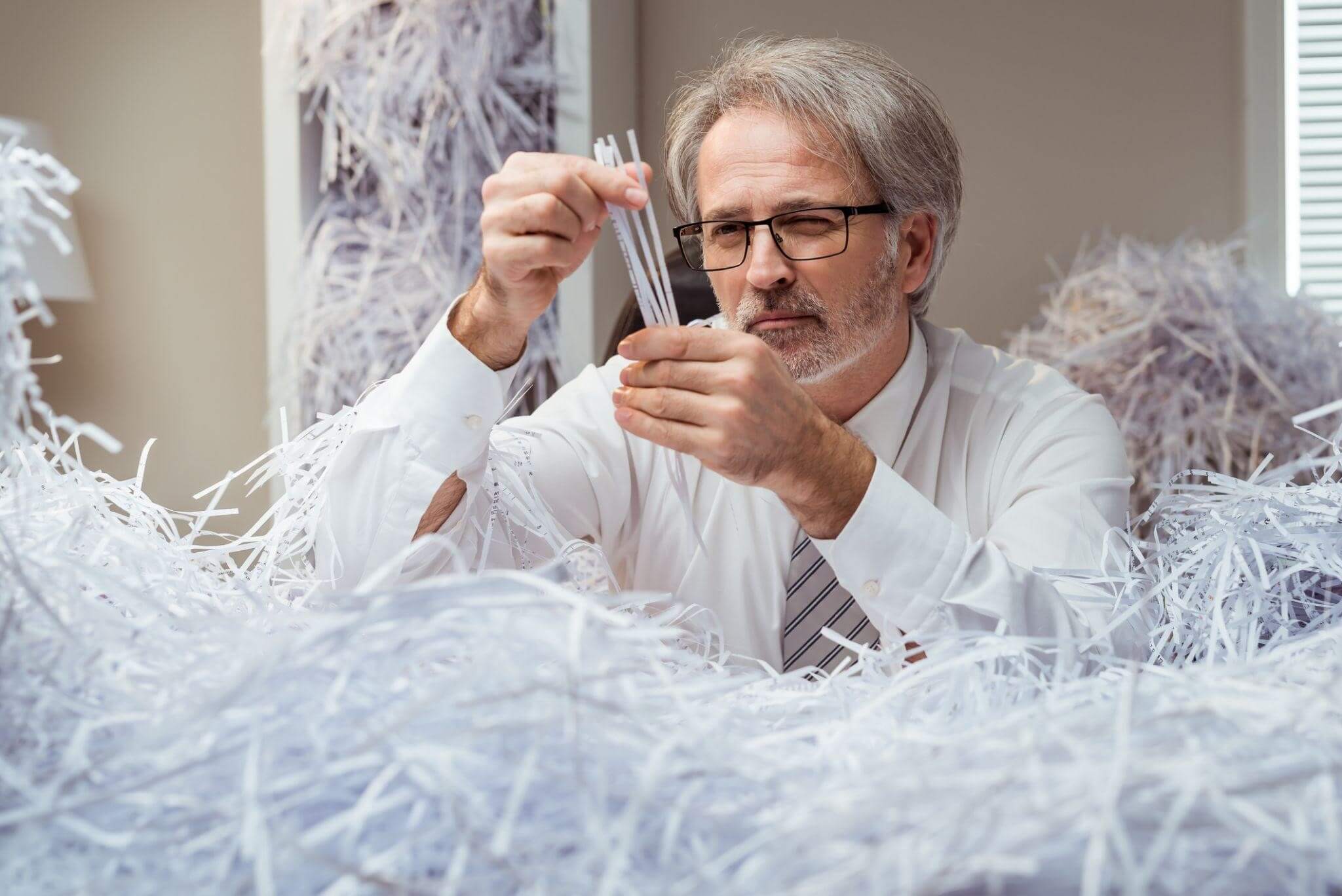 man in suit try to put together the paper 