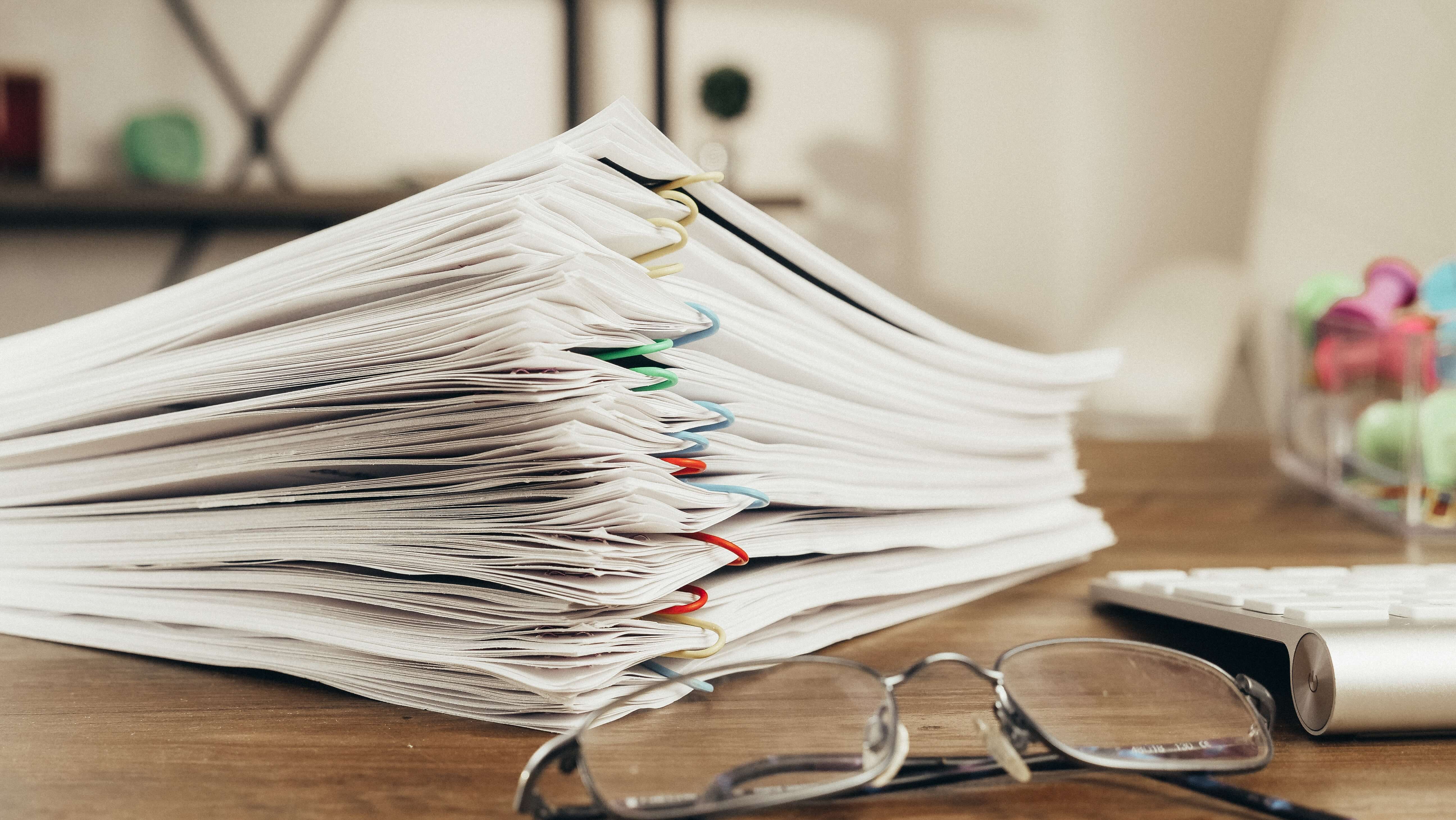 paper files stacked on desk