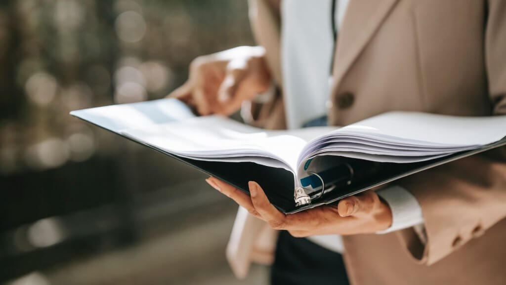 woman holding file of documents in her hands