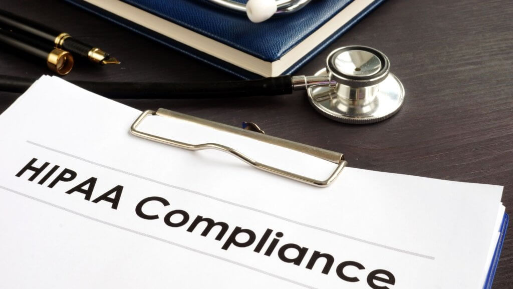 A clipboard with a document that says HIPAA Compliance